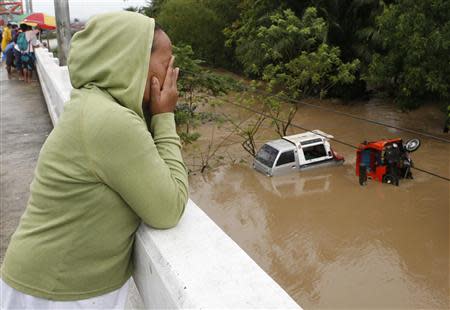 A woman weeps after her house was swept away during heavy flooding brought by tropical depression "Agaton", in Butuan on the southern Philippine island of Mindanao January 21, 2014. REUTERS/Erik De Castro