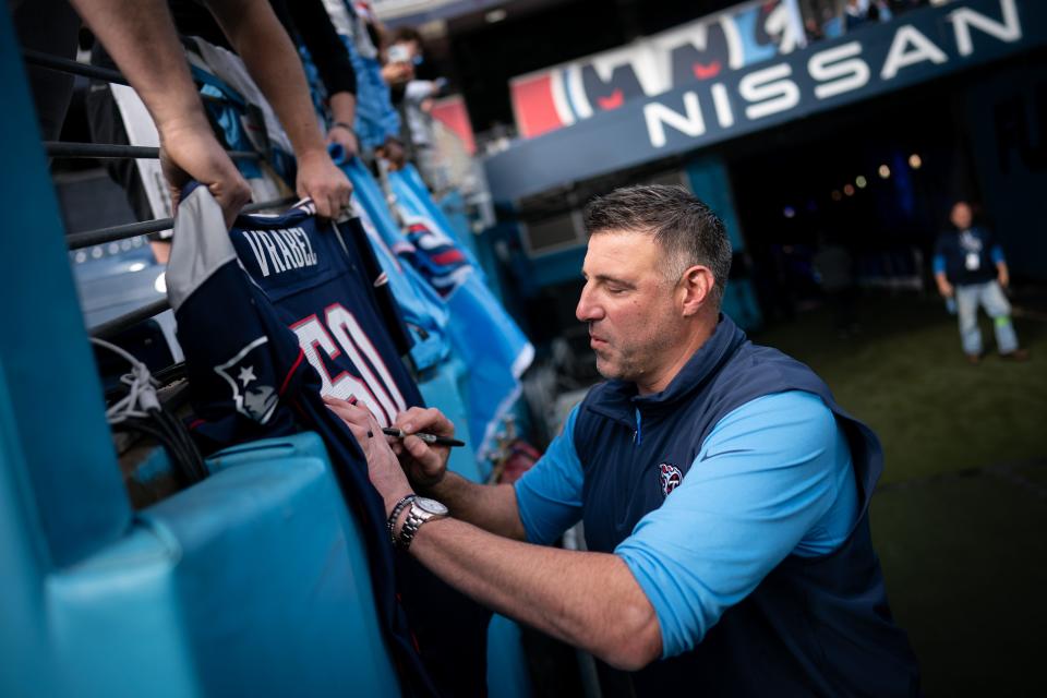 Tennessee Titans head coach Mike Vrabel signs autographs before a game against the Seattle Seahawks in Nashville, Sunday, Dec. 24, 2023.