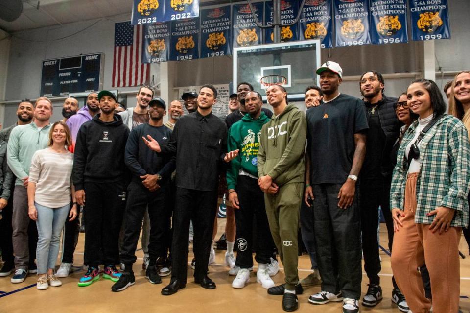 NBA star Devin Booker poses for a photo with his Phoenix Suns teammates following a ceremony for the retirement of Booker’s high school jersey at Moss Point High School in Moss Point on Saturday, Dec. 10, 2022.