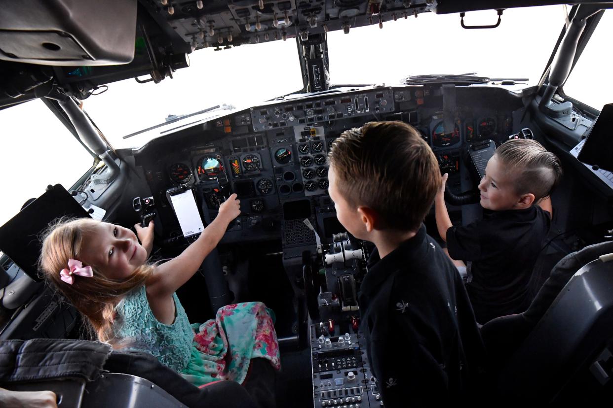 Madison Everson, 8, looks up from behind the yoke of the Boeing 737 firefighting aircraft Wednesday. Joining her in the aircraft's cockpit as "copilots" are her brothers A.J. (center) and Derrick, 4 and 6, respectively. The aircraft was instrumental over the weekend in fighting the Hill Top Fire south of Abilene, local leaders gathered to thank the aircrews Wednesday before they flew off to other fires closer to Louisiana.