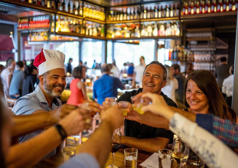 From left, Michael Bates of Northville, Mike Boguth of Birmingham and Jean Boguth of Birmingham join others from their table to do a shot of limoncello before desert arrives during the Detroit Free Press/Metro Detroit Chevy Dealers Top 10 Takeover at SheWolf in Detroit in July 2019.