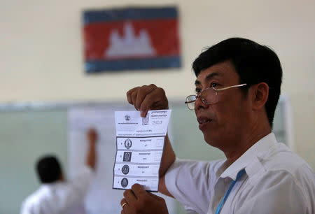 A member of the National Election Committee (NEC) shows a ballot as he counts ballot papers during a Senate election in Phnom Penh, Cambodia February 25, 2018. REUTERS/Samrang Pring