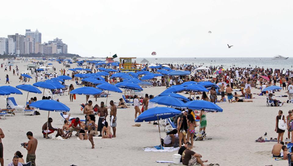 FILE - In this Friday, May 28, 2010, file photo, tourists and local residents enjoy a day the the beach as Memorial Day weekend begins in the South Beach area of Miami, Beach, Fla. With a little advance planning, and some insider tips, summer vacations can be a lot less expensive. (AP Photo/Alan Diaz, File)