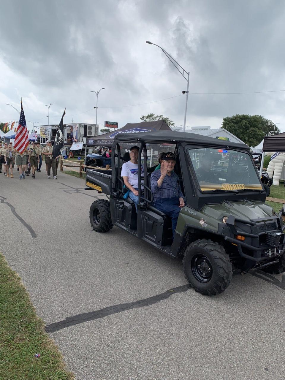 Richard Janssens, a veteran, waves from a Ranger Crew side-by-side driven by Sheriff's Deputy Jeremy Lestock, during a Veterans Day procession at the Monroe County Fair Monday. Riding in the back seat were Dennis Urbanczyk, an Air Force veteran, and his wife, Rose Hopkins, of Newport.