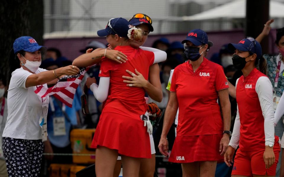 Nelly Korda, of the United States, center, is congratulated by her teammates after winning the gold medal on the 18th hole during the final round of the women's golf event at the 2020 Summer Olympics, Saturday, Aug. 7, 2021, at the Kasumigaseki Country Club in Kawagoe, Japan. - AP Photo/Andy Wong