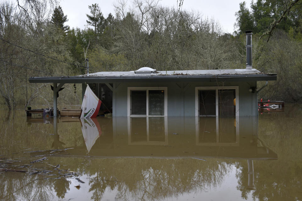 A California state flag hangs from the front of a home submerged in the flood waters of the Russian River in Forestville, Calif., on Feb. 27, 2019. (Photo: Michael Short/AP)