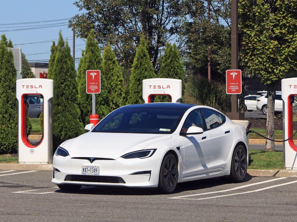 A white Tesla Model S at a charging station