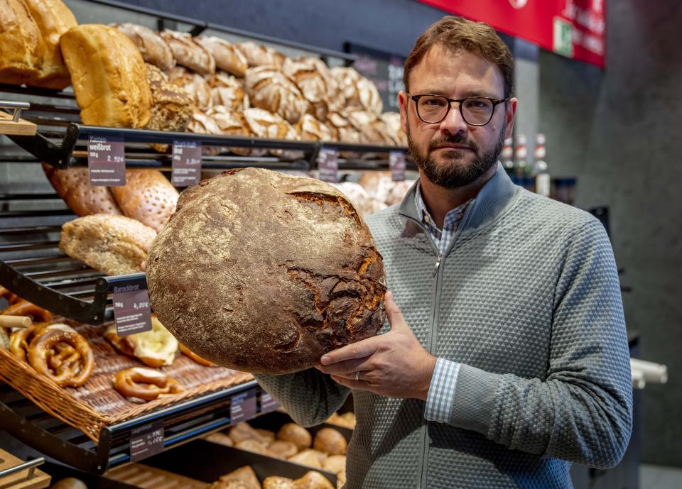 Baker Andreas Schmitt shows a loaf of bread in one of his branches in Neu Isenburg, Germany, Monday, Sept. 19, 2022. Schmitt is heating fewer ovens at his 25 Ernst Cafe bakeries, running them longer to spare startup energy, narrowing his pastry selection to ensure ovens run full, and storing less dough to cut refrigeration costs. (AP Photo/Michael Probst)