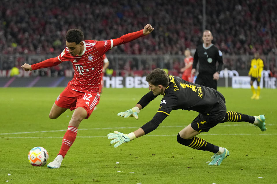 Jamal Musiala de Bayern Munich dispara frente al portero del Borussia Dortmund Gregor Kobel en el encuentro de la Bundesliga el sábado 1 de abril del 2023. (AP Foto/Matthias Schrader)