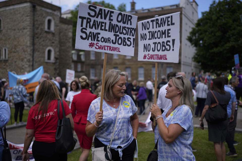 People who work in the UK aviation and travel industry take part in a 'Travel Day of Action' protest across the street from the Houses of Parliament in London, Wednesday, June 23, 2021. The protest on Wednesday was attended by people from across the UK aviation and travel industry calling on the British government to safely reopen international travel for the peak summer season to protect travel jobs and businesses amidst Britain's widely praised rollout of coronavirus vaccines. (AP Photo/Matt Dunham)