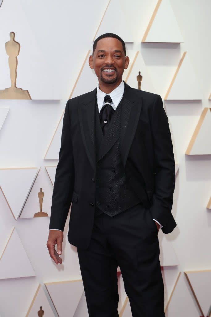 Will in a formal suit with a tie posing with a smile on the red carpet