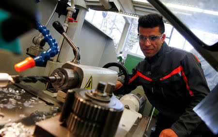 FILE PHOTO - Qudratullah Hotak, a 23-year-old refugee from Afghanistan works with a driller at the training workshop of Ford Motor Co in Cologne, Germany, November 3, 2016. REUTERS/Wolfgang Rattay/File Photo