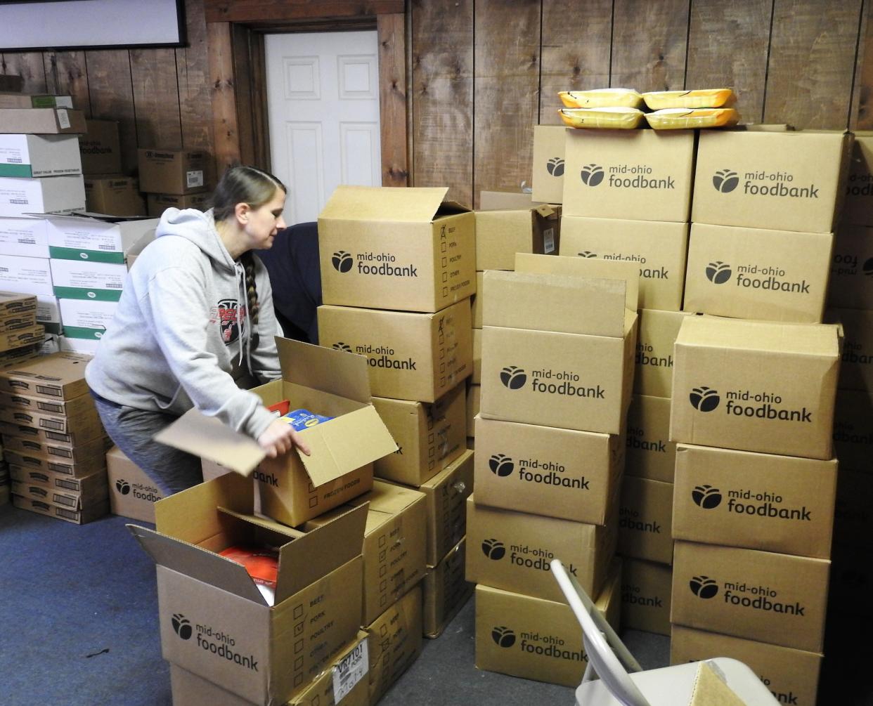 Nichole Braxton unpacks boxes from the Mid-Ohio Food Bank at Upper Room Assembly and Worship Center. The church is seeking funds to construct a permanent pantry building with drive-thru access.