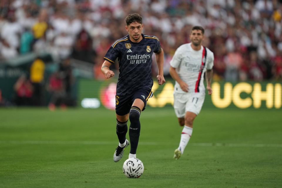 Real Madrid midfielder Federico Valverde (15) moves the ball against AC Milan in the first half at the Rose Bowl.