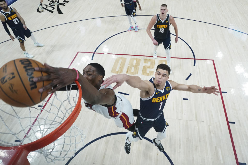 Miami Heat center Bam Adebayo, left, dunks while defended by Denver Nuggets forward Michael Porter Jr. (1) during the second half of Game 2 of basketball's NBA Finals, Sunday, June 4, 2023, in Denver. (AP Photo/Mark J. Terrill, Pool)