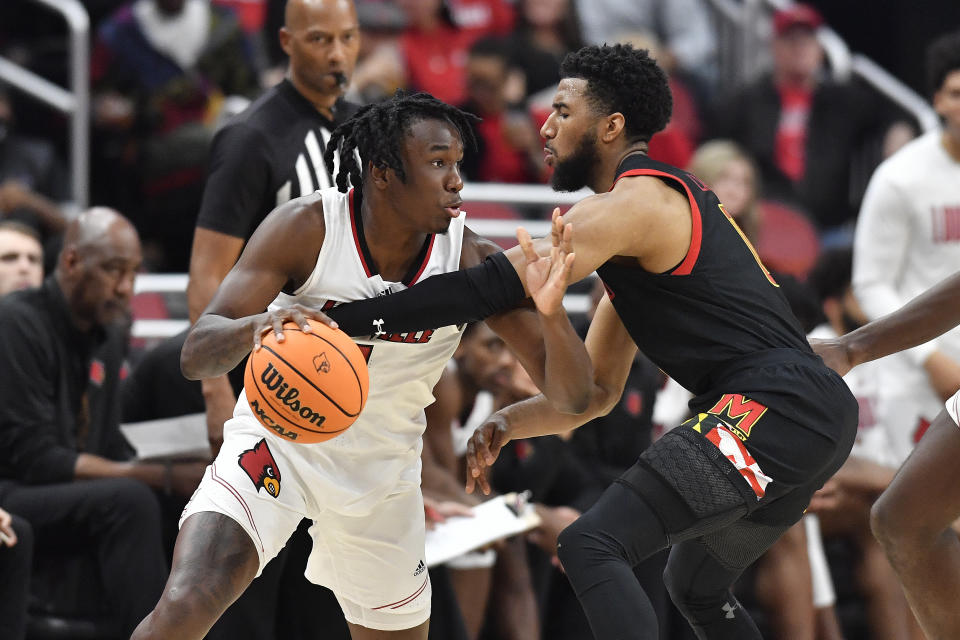 Maryland guard Don Carey attempts to strip the ball away from Louisville guard Mike James during the second half of an NCAA college basketball game in Louisville, Ky., Tuesday, Nov. 29, 2022. Maryland won 79-54. (AP Photo/Timothy D. Easley)