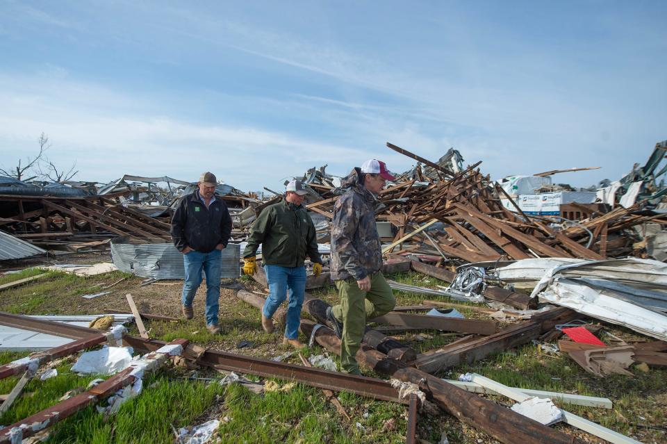 Brett Bailess, from right, with Service Lumber Company in Rolling Fork, and local farmers Charles Durst of Delta City and Jeffrey Mitchell of Cary, walk through the remains of the store Tuesday talking about what needs to be done next. The store was destroyed when a tornado slammed the small Delta town. The farmers are helping to clear an area to put up a temporary shelter.