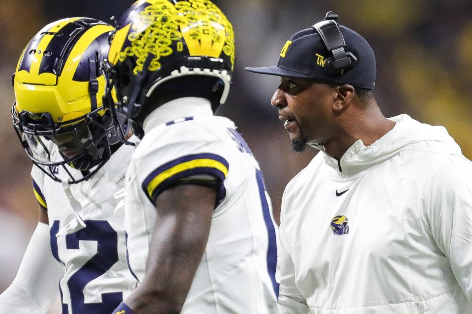 Michigan co-defensive coordinator Steve Clinkscale, right, talks to players at a timeout during the second half of U-M's 26-0 win over Iowa in the Big Ten championship game in Indianapolis on Saturday, Dec. 2, 2023.