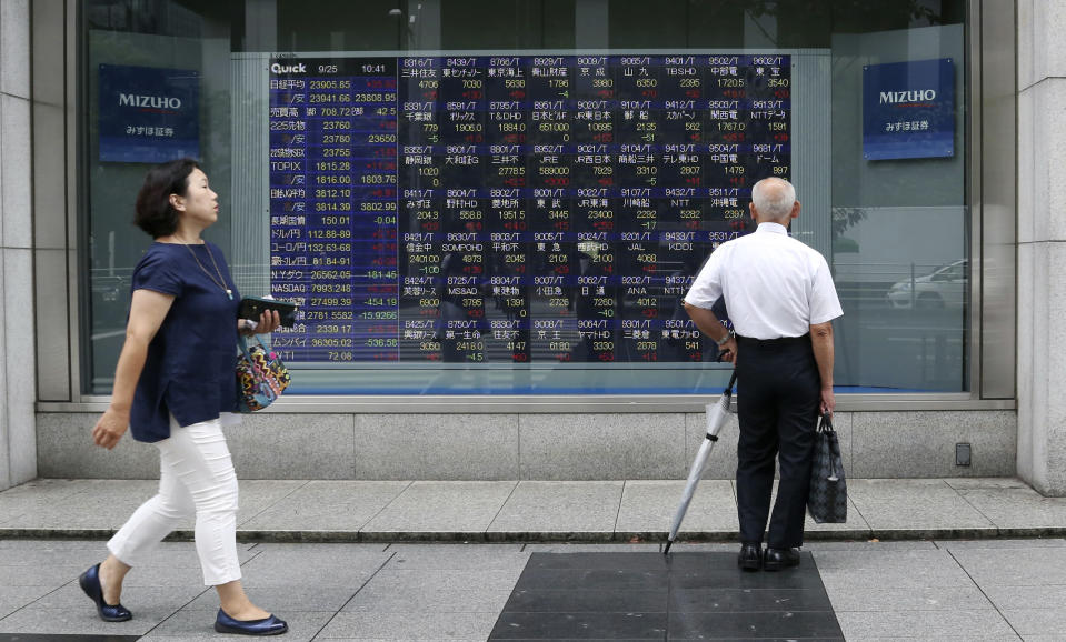 A man looks at an electronic stock board of a securities firm in Tokyo, Tuesday, Sept. 25, 2018. Asian stock markets were mostly lower Tuesday after a Chinese government report accusing the Trump administration of bullying other countries dampened hopes for a settlement in their escalating tariff war. (AP Photo/Koji Sasahara)