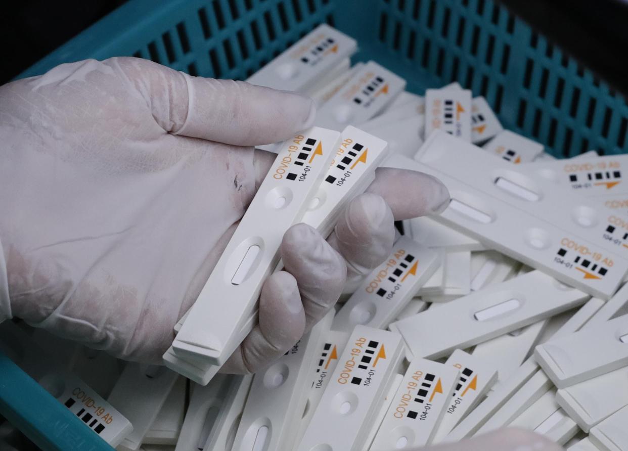 An employee holds antibody test cartridges of the ichroma COVID-19 Ab testing kit used in diagnosing the coronavirus on a production line of the Boditech Med Inc. in Chuncheon, South Korea.