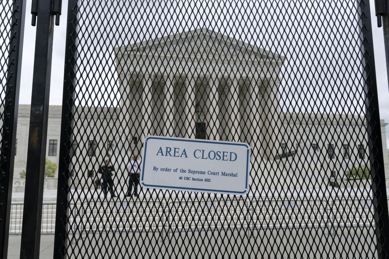 U.S. Supreme Court building, seen through a fence with sign that reads: Area closed by order of the Supreme Court Marshall 40 USC Section 6102.