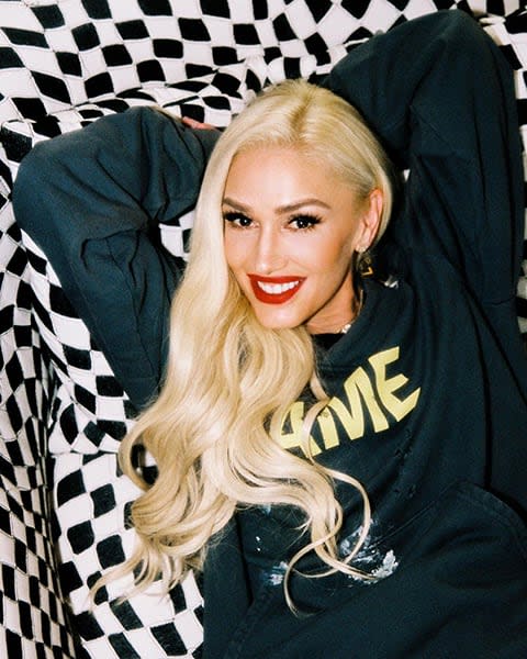 gwen stefani smiling reclining on couch