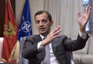 In this photo taken Monday, Nov. 11, 2019, Montenegrin Defense Minister Predrag Boskovic speaks and gestures during an interview with The Associated Press in Montenegro's capital Podgorica. Deployed inside the sprawling communist-era army command headquarters in Montenegro’s capital, a group of elite U.S. military cyber experts are plotting strategy in a fight against potential Russian and other cyberattacks ahead of the 2020 American and Montenegrin elections. (AP Photo/Risto Bozovic)