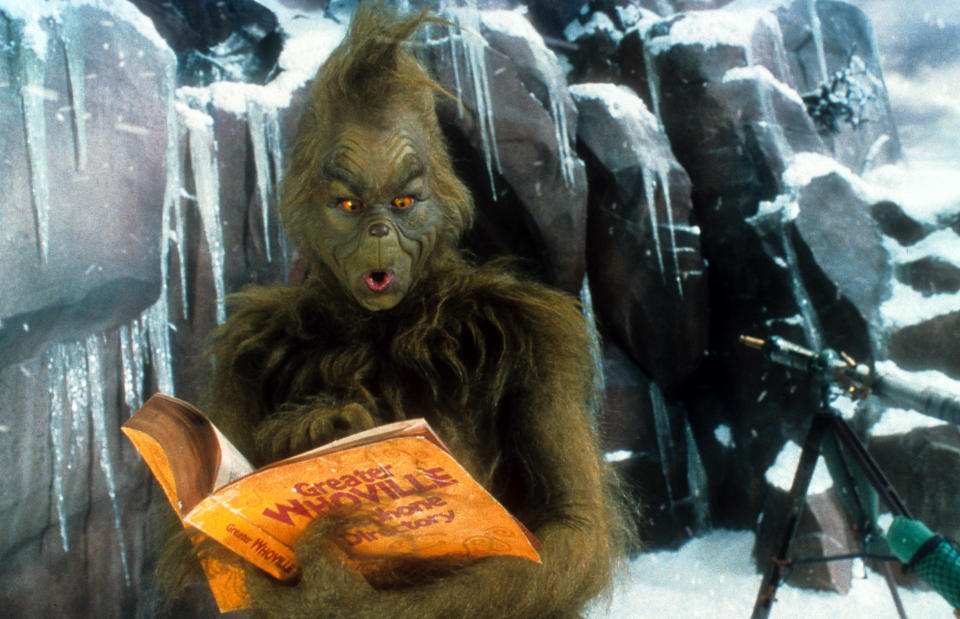 Jim Carrey looking through phone directory in a scene from the film 'How The Grinch Stole Christmas', 2000. (Photo by Universal/Getty Images)