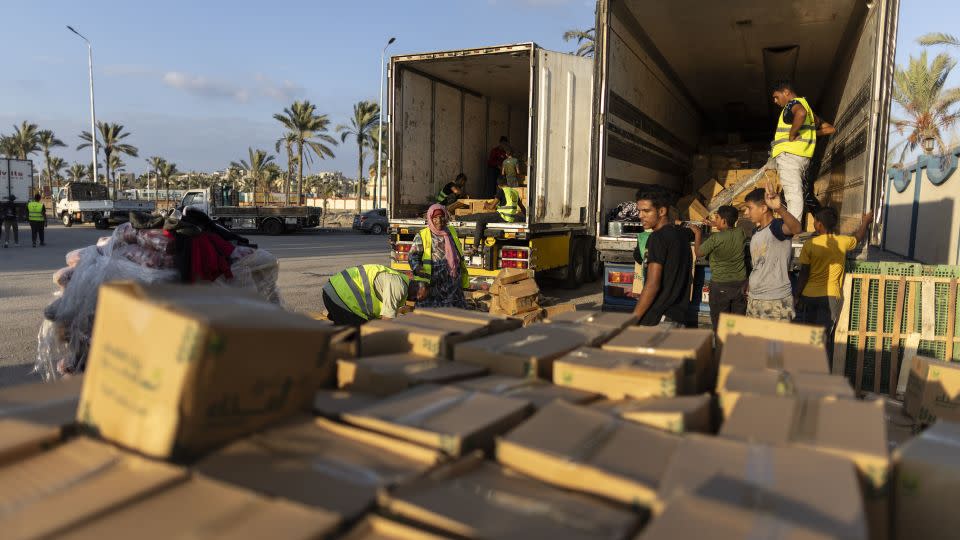 Volunteers load food and supplies onto aid trucks on October 16, in North Sinai, in Egypt. Israeli strikes have blocked efforts to bring humanitarian aid into Gaza through the Rafah crossing. - Mahmoud Khaled/Getty Images