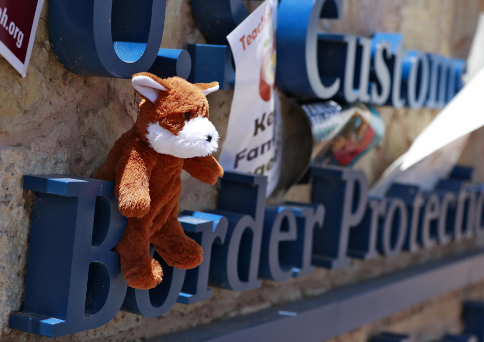 FILE - A teddy bear is left on the sign of U.S. Customs and Border Protection at the port-of-entry, June 26, 2018, in Fabens, Texas along the international border where immigrant children are being held. A group tried to deliver items to the children housed in tents at the facility but were turned away. The Biden administration is asking that parents of children separated at the U.S.-Mexico border undergo another round of psychological evaluations in an effort to measure how just traumatized they were by the Trump-era policy, court documents show. (AP Photo/Matt York, File)