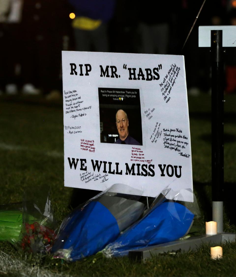 A sign pays tribute to Pilgrim High School Principal Gerald Habershaw, who passed away on Saturday. A candlelight vigil on Sunday night brought out a crowd of people to honor the late educator.