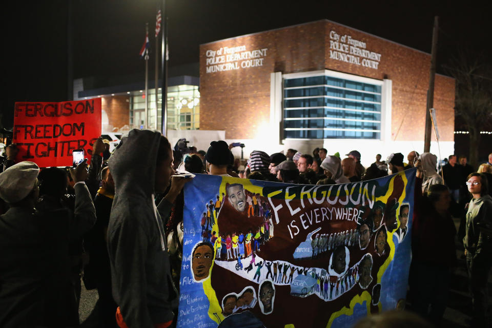 Demonstrators protests in front of the police station on March 12, 2015 in Ferguson, Missouri. Two police officers were shot yesterday while standing outside the station observing a similar protest. Ferguson has faced many violent protests since the August shooting death of Michael Brown by a Ferguson police officer. 