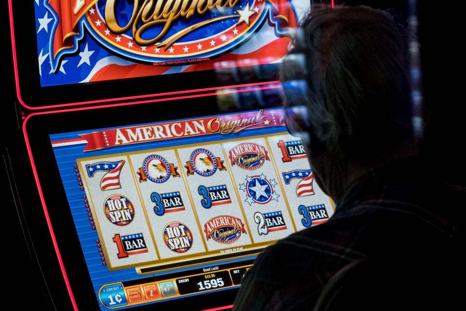 A man plays a video slot machine in a lounge at Huck's, a truck stop in Mount Vernon, Illinois. Similar video slot machines occupy gas stations and convenience stores throughout Missouri, operating illegally; discussions of legalizing the machines in the Missouri legislature have frequently been entangled with legalization of sports betting.