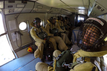 Rookie smokejumper Brian Anderson (R) prepares to jump from an airplane with fellow smokejumpers while flying above Winthrop, Washington, U.S., June 30, 2016. REUTERS/David Ryder