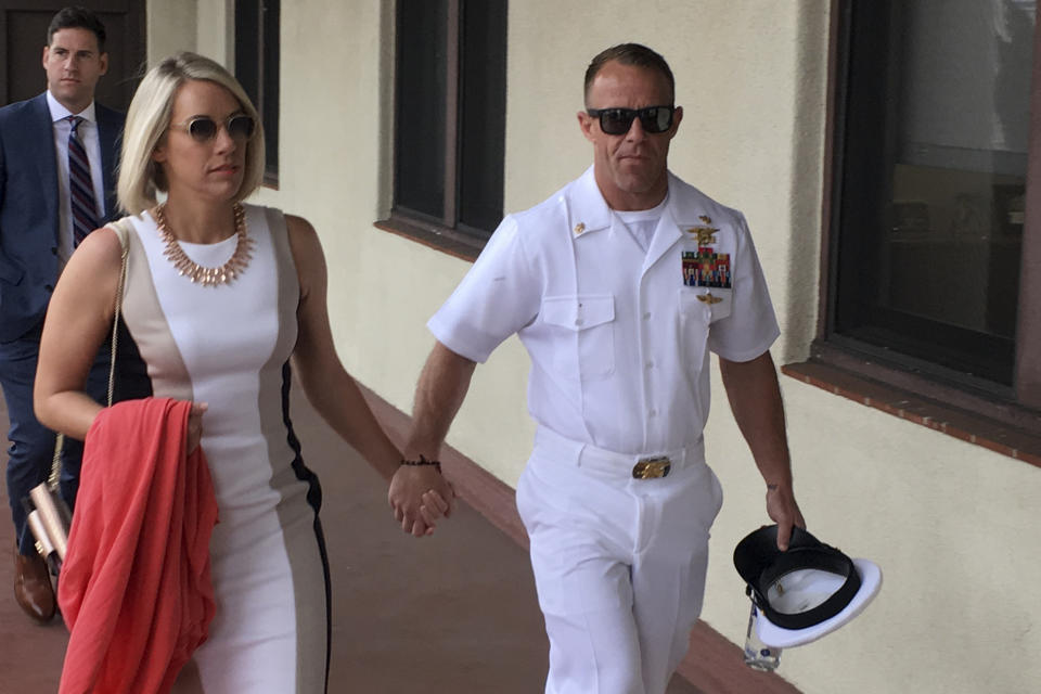 Navy Special Operations Chief Edward Gallagher, right, walks with his wife, Andrea Gallagher as they arrive to military court on Naval Base San Diego, Tuesday, June 18, 2019, in San Diego. Jury selection continued Tuesday morning in the court-martial of the decorated Navy SEAL, who is accused of stabbing to death a wounded teenage Islamic State prisoner and wounding two civilians in Iraq in 2017. He has pleaded not guilty to murder and attempted murder, charges that carry a potential life sentence. (AP Photo/Julie Watson)