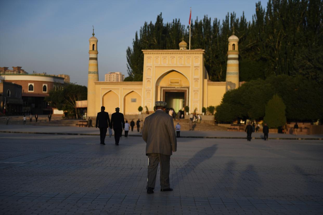 <p>A Uighur walks towards the Id Kah mosque in China’s western Xinjiang region</p> (AFP/Getty)