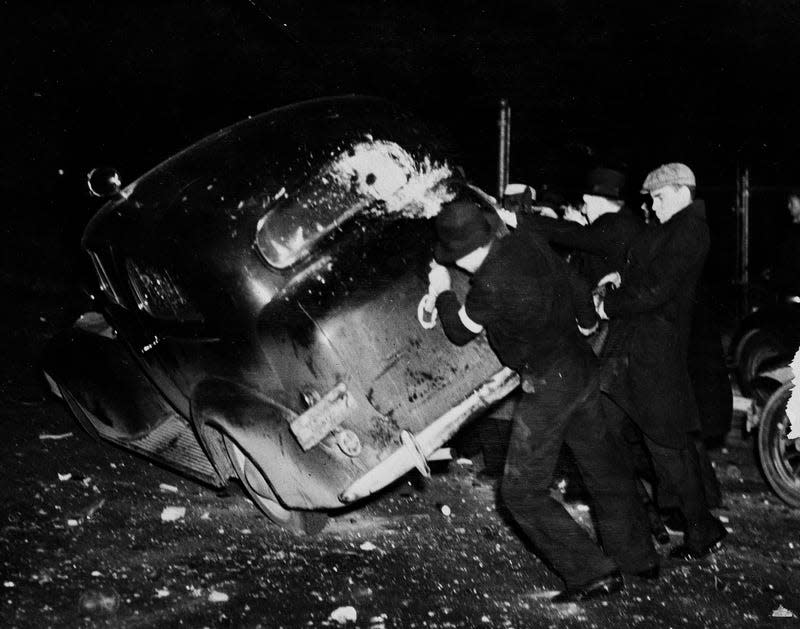 A group of strike sympathizers is shown tipping over an automobile  loaded with sheriff’s deputies during the riot at the strike-closed  Fisher Body#2