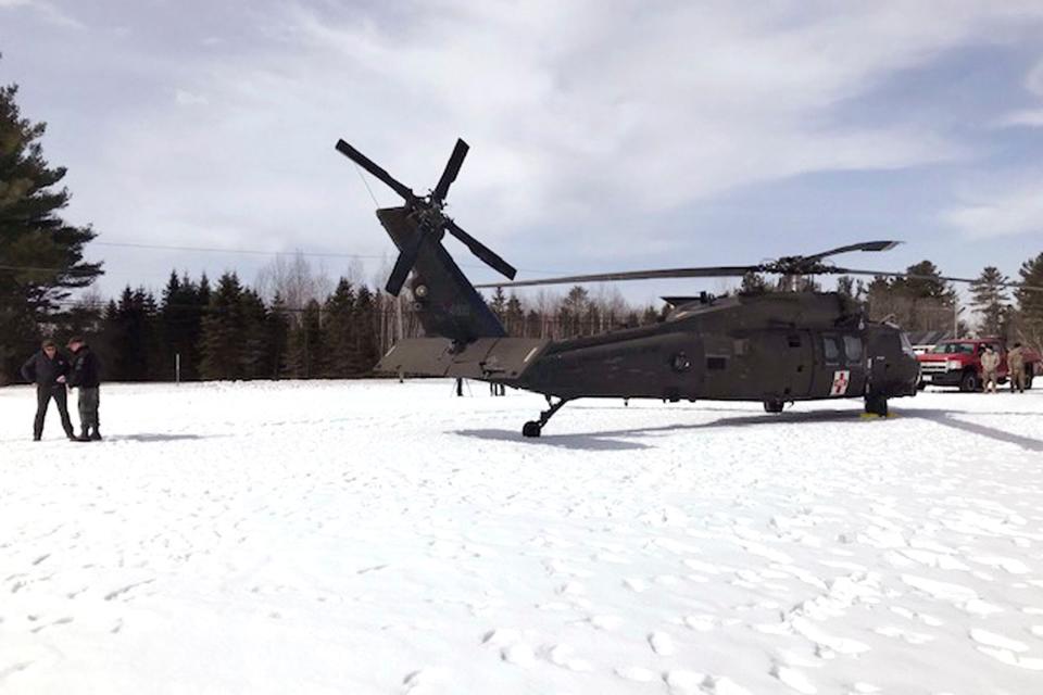 In this U.S. Army photograph by attorney Douglas Desjardins, a damaged Black Hawk helicopter rests on the snow, March 13, 2019, in Worthington, Mass. A Massachusetts man wants the government to pay nearly $10 million after being badly injured in a crash with a Black Hawk helicopter. The lawsuit filed by Jeffrey Smith against the government follows a 2019 crash in which Smith's snowmobile collided with the helicopter that was parked on a trail at dusk. (U.S. Army photograph provided by attorney Douglas Desjardins via AP)