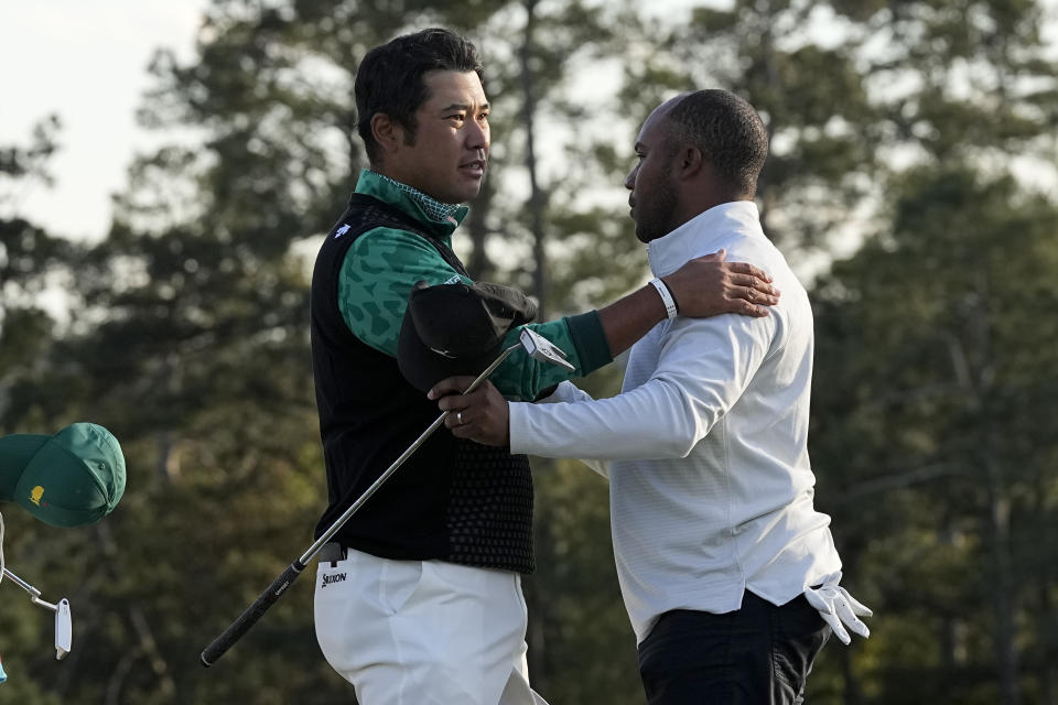 Hideki Matsuyama, of Japan, greets Harold Varner III on the 18th green during the third round at the Masters golf tournament on Saturday, April 9, 2022, in Augusta, Ga. (AP Photo/David J. Phillip)