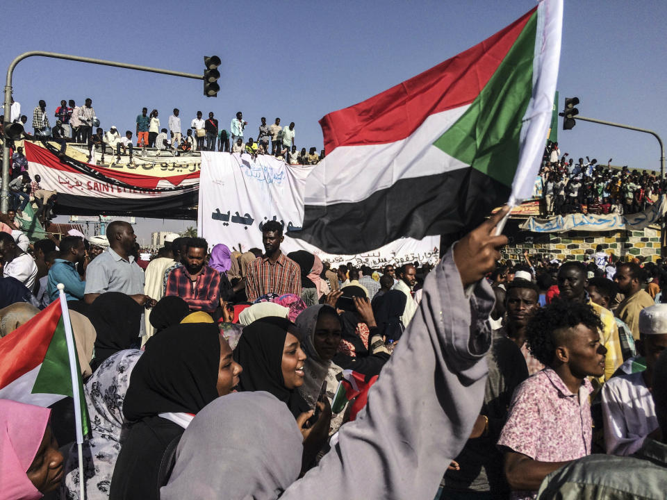 Sudanese demonstrators march with national flags as they gather during a rally demanding a civilian body to lead the transition to democracy, outside the army headquarters in the Sudanese capital Khartoum on Saturday, April 13, 2019. The military overthrew President Omar al-Bashir on Thursday after almost four months of protests calling for an end to his nearly 30-year rule. (AP Photo)