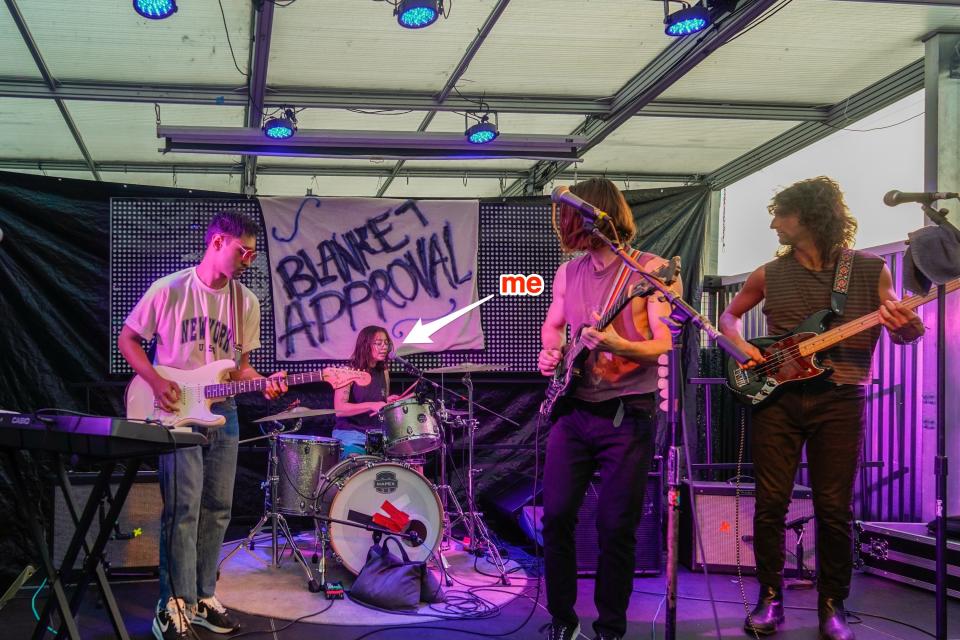 An arrow points to the author playing drums on stage