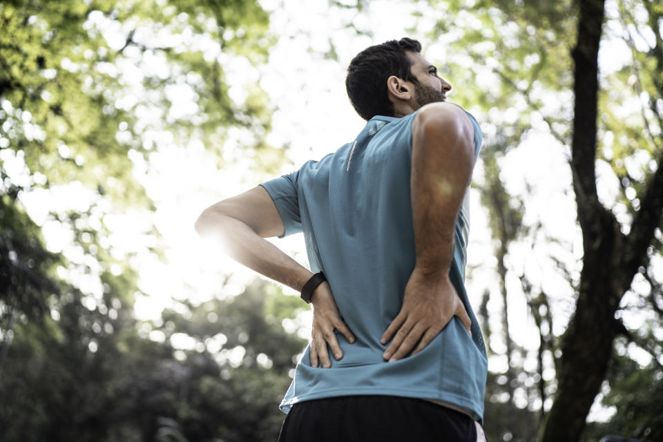 Man feeling backache at a park