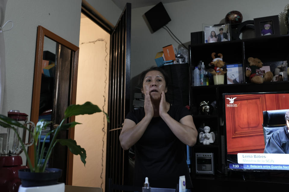 Domestic worker Concepcion Alejo rubs her face with creme as she gets ready for work, in her apartment in Mexico City, Wednesday, April 24, 2024. Alejo is among approximately 2.5 million Mexicans — largely women — who serve as domestic workers in the Latin American nation. (AP Photo/Marco Ugarte)