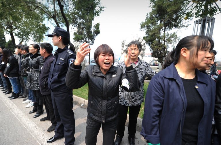 A woman cries as the coffin of retired local Communist Party chief Wu Renbao is driven through Huaxi village on March 22, 2013