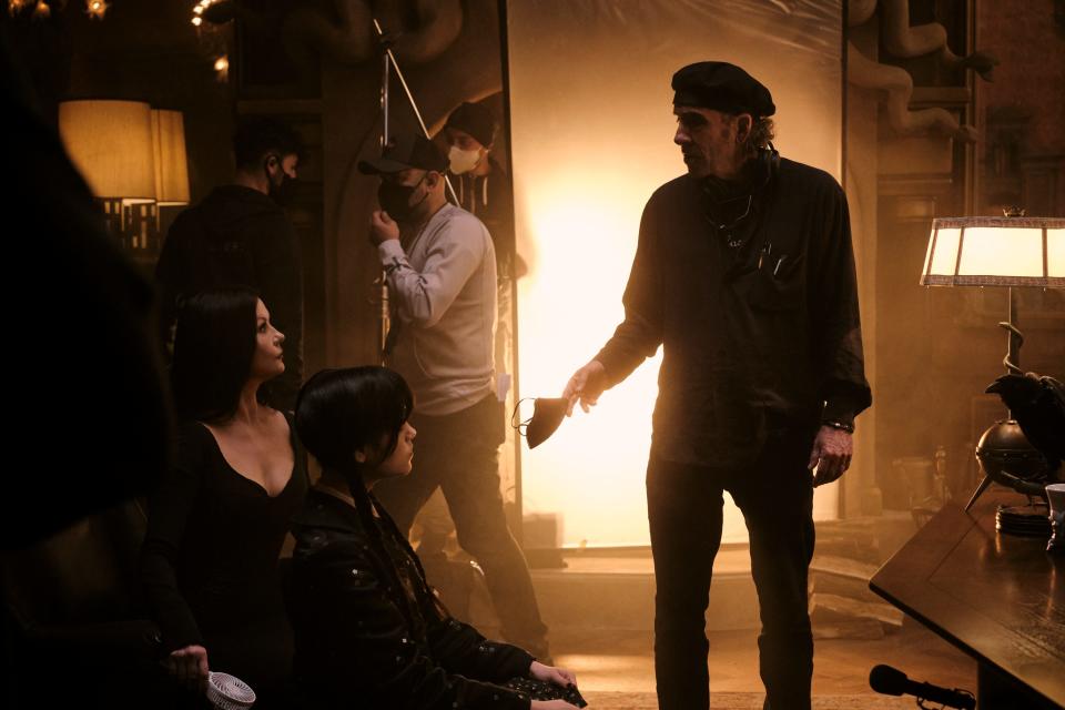 Director Tim Burton goes over a scene with stars Catherine Zeta-Jones and Jenna Ortega on the set of "Wednesday."