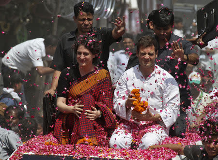 Rahul Gandhi (in white) and his sister Priyanka Gandhi Vadra are showered with rose petals by their supporters upon Rahul's arrival to file his nomination for the general election at Amethi, Uttar Pradesh April 12, 2014. REUTERS/Pawan Kumar/Files