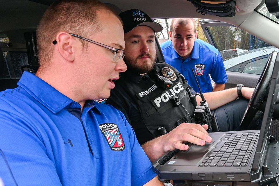 Sgt. Alex Watlington of Middle Tennessee State University’s Police Department, center, shows MTSU’s newest recruits Lealand Wood, left, and Tristan Slater how to operate a patrol vehicle’s computer on campus in November 2022.