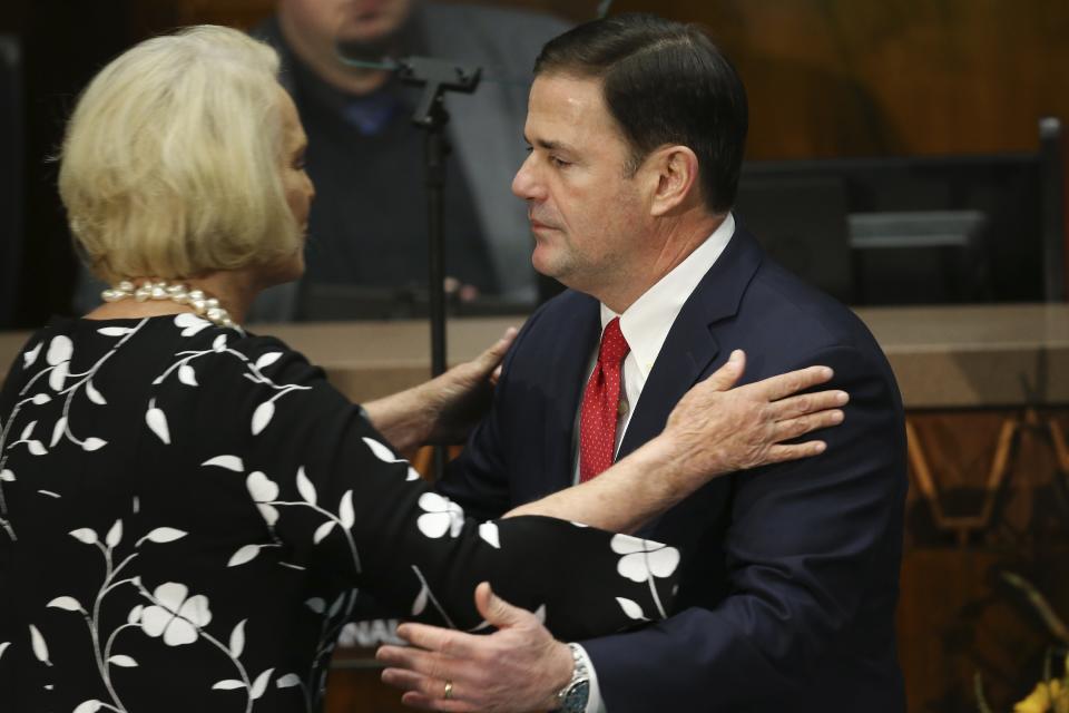 FILE - In this Jan. 13, 2020, file photo, Arizona Republican Gov. Doug Ducey, right, hugs Cindy McCain, left, after delivering his State of the State address on the opening day of the legislative session at the Capitol in Phoenix. The Arizona Republican Party is confronting its future this weekend after losing a second Senate seat and the presidential race. On the agenda for the state committee meeting Saturday: the reelection bid by its controversial chairwoman, who has been among the most prolific promoters of baseless election conspiracies, and the censure of some of the party's best-known figures: Cindy McCain, former Sen. Jeff Flake and Gov. Doug Ducey. (AP Photo/Ross D. Franklin, File)