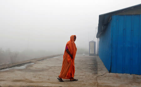 A woman tries to stay warm during heavy fog in Delhi, India December 1, 2016. REUTERS/Cathal McNaughton TPX IMAGES OF THE DAY