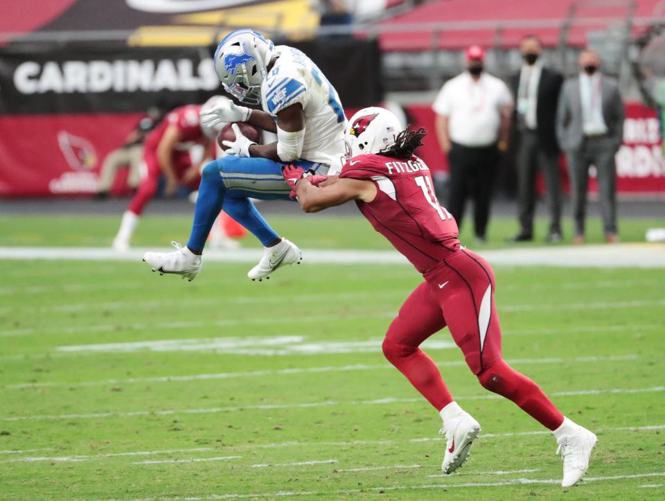 Cardinals wide receiver Larry Fitzgerald breaks up a possible interception by Lions strong safety Duron Harmon during the third quarter of the Lions' 26-23 win on Sunday, Sept. 27, 2020, in Glendale, Ariz.